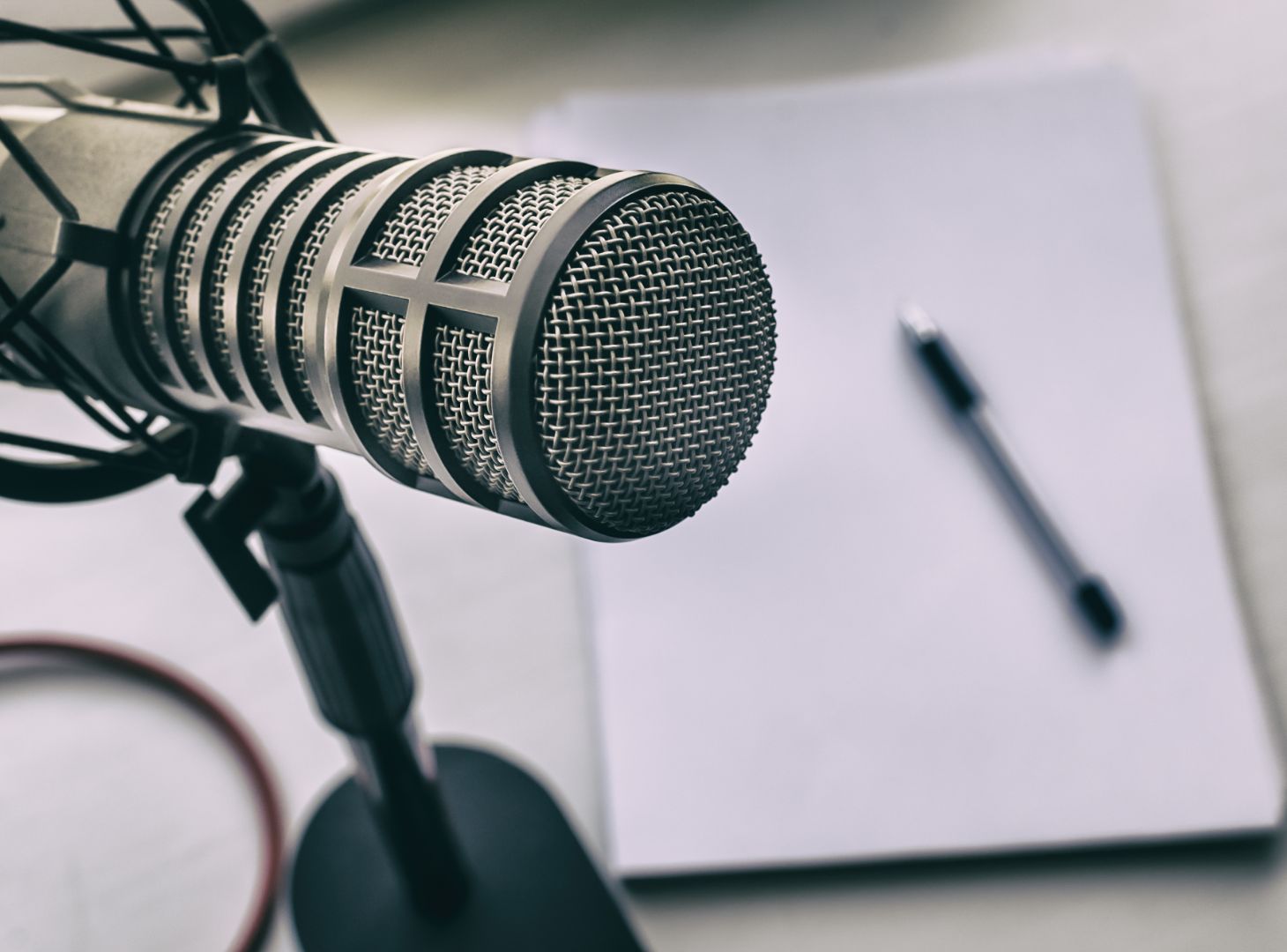 Image of a microphone on a table next to a pen and paper